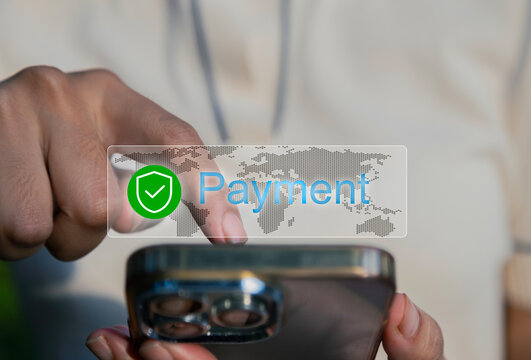 Young girl is using a smartphone to make a secure online payment. A digital overlay shows a checkmark in a green shield with the word "Payment" over a world map background, indicating success.