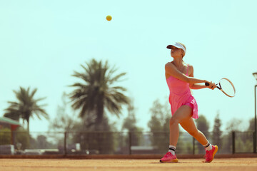 Woman tennis player plays tennis on the tennis court.