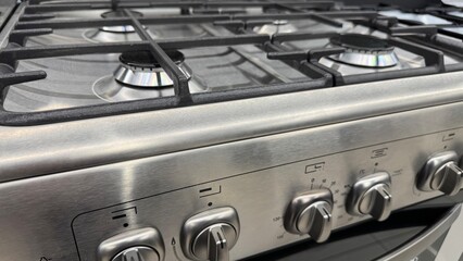 Modern stainless steel gas stove with multiple burners and metal control knobs