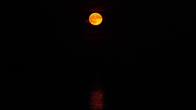 Red strawberry moon rises over the Greifswalder Bodden in June 2025. Mystical glow reflects on the water. The video excerpt of 17 seconds is 86 MB in size. The frame rate is 50 pps.