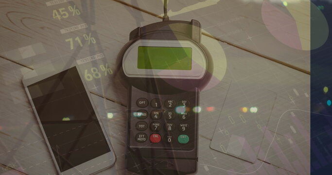 Showing credit card payment terminal processing payment on desk, with smartphone  and  two credit ca - Powered by Adobe