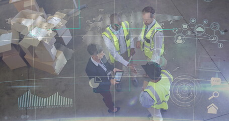 Collaborating warehouse team in neon vests analyzing map overlay on tablet inside distribution hub
