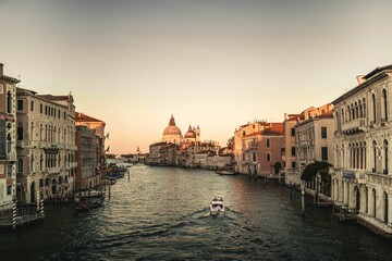 Fototapeta premium a boat traveling through the water with buildings along side of it