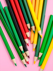 Fototapeta premium Arrangement pencils set in red green yellow gradine colors on pink background