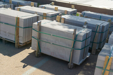 high angle view of large grey concrete slabs stacked on wooden pallets, concept of building...