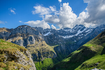 Fototapeta premium Breathtaking mountain landscape showcasing lush valleys and rugged peaks under a vibrant sky in a remote location