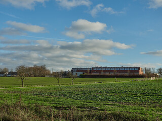 Green meadow on the foreground of the building under the cloudy sky