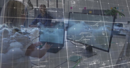 Typing woman at laptop and man working at dual monitors in office, with cloud computing graphics