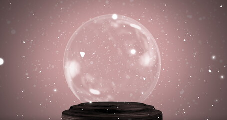 Displaying transparent glass sphere resting on dark wooden pedestal in studio, with white particles