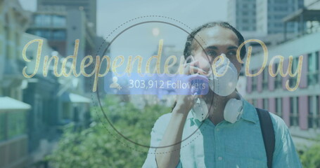 Adult male wearing mask talking on phone on rooftop terrace, Independence Day overlay, copy space