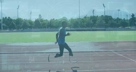 Sprinting teenage boy wearing blue sleeveless top on red track, with running prosthetic blades