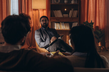 Naklejka premium Married couple argues during session while bearded psychotherapist observes interaction of patients