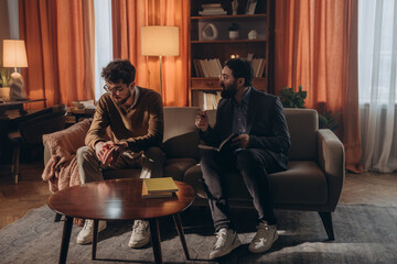 Male psychotherapist sits on couch with patient offering guidance