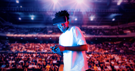 Adult holding joystick and wearing VR goggles while enjoy playing games at stadium with blurring...