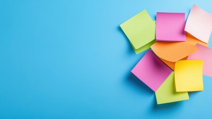 Fototapeta premium Colorful sticky notes arranged on a blue background for creative planning