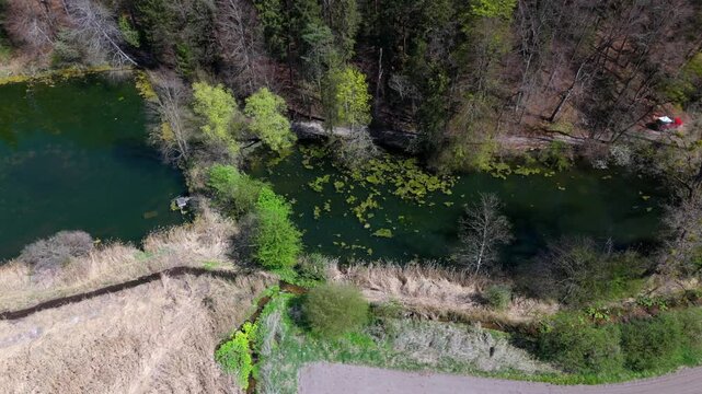 Stunning aerial view of Spiegelweiher serene lake chain near Grafing bei Muenchen, Bavaria, Deutschland. Crystal clear waters, lush spring greenery and trails create perfect scene for nature lovers. 