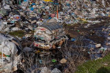 Piles of plastic and garbage fill a landfill area, showcasing the ongoing struggle with pollution...