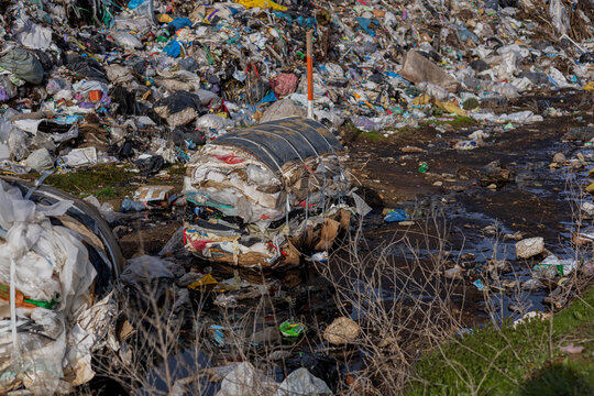 Piles of plastic and garbage fill a landfill area, showcasing the ongoing struggle with pollution and environmental impact on ecology