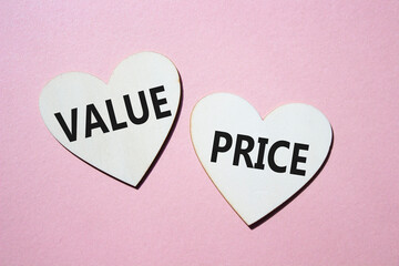 Price and Value symbol. Concept word Price and Value on wooden hearts. Beautiful pink background....