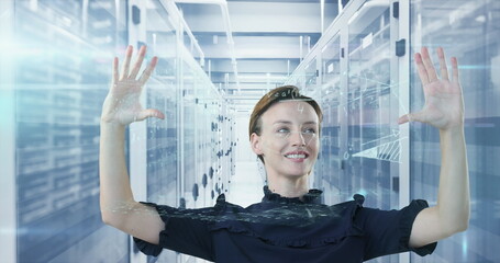 Engineer in ruffled top using holographic display in data center aisle, with server racks