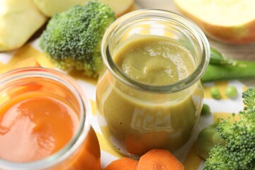 Baby food. Tasty puree in glass jars and ingredients on table, closeup