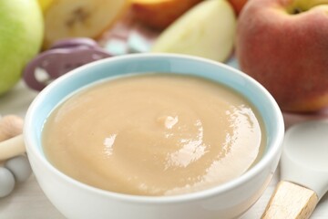 Baby food. Tasty puree in bowl, different ingredients, teether and pacifier on table, closeup