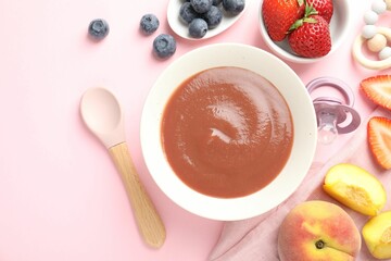 Baby food. Tasty puree in bowl, pacifier, teether and ingredients on pink background, flat lay