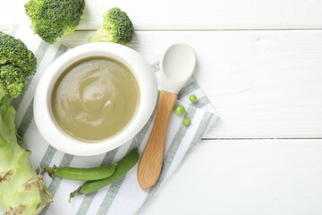 Baby food. Tasty puree in bowl, spoon and ingredients on white wooden table, flat lay. Space for...