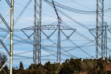 High voltage power lines crossing green rural terrain.