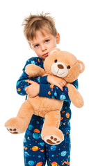 A young boy in pajamas cuddling a teddy bear.