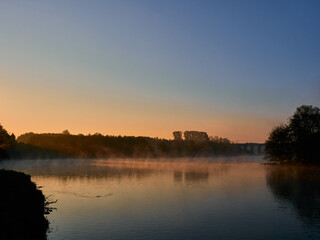 Closeup shot of a landscape with river and reflection of trees during sunset