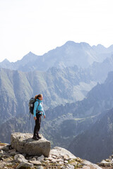 Girl hiker standing on rock admiring Tatra mountains in Slovakia