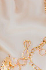 Golden jewelry accessories arranged on soft fabric background for elegant display