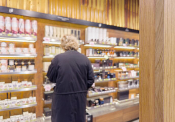 Man buying make up at cosmetics section in store. choosing cosmetics, perfumes, creams and shampoos, Using tester.