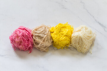 Traditional Turkish sweet. Pismaniye. Light halva, sweet cotton in the form of threads in a ball. With the aroma of melon, vanilla, chocolate, pomegranate. White background. Copy space