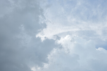 Summer sky before the rain. A dark cloud is crawling on a white cloud. Background image.