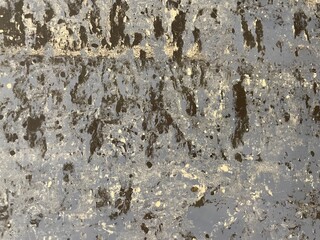 Surface of old wall painted in black and gold colors. Close-up of texture as background for design....