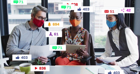 Three mask-wearing colleagues reviewing documents in conference room, with social media metrics