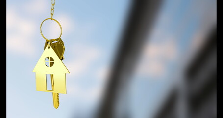 Dangling gold house-shaped keyring charm at modern building facade, with attached keys, copy space