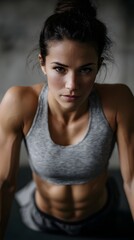Fit and focused woman displaying toned abdominal muscles during intense gym workout
