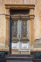 Old neoclassical building door with decorative wrought iron grilles in limassol, cyprus
