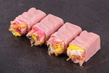 Angel Hair. Raspberry white chocolate candy bar. With colored cotton candy. Dark background. Close-up.