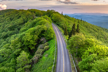 Obraz premium Blue Ridge Parkway road in summer woods of Appalachian mountains with green canopies in colorful forest. Road trip driving in wild nature in summertime season