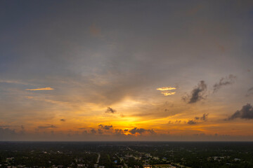 Bright colorful orange and yellow clouds over dark horizon. Beautiful sunset sky scenery