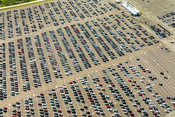 Obraz premium Car factory parking lot with brand new cars ready for export sale. Development of automotive industry in USA concept