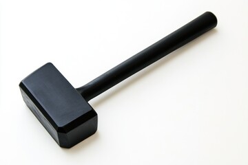 A single black sledgehammer with a long handle laying diagonally on a white background surface