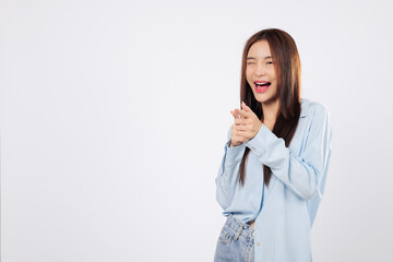 Woman uses finger gun in a cheeky what up pose, while another woman points at the guy playfully with a friendly attitude, both standing in studio isolated on white background.