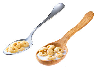 Whole grain cereal rings with milk in a metal spoon isolated on white background.
