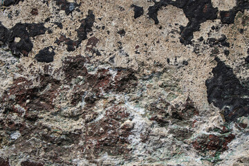 an old concrete wall with rough, weathered patches of dark and light colors. abstract grunge texture background with copy space