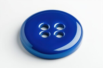 A close up shot of a shiny blue button with four holes on a white surface in bright lighting